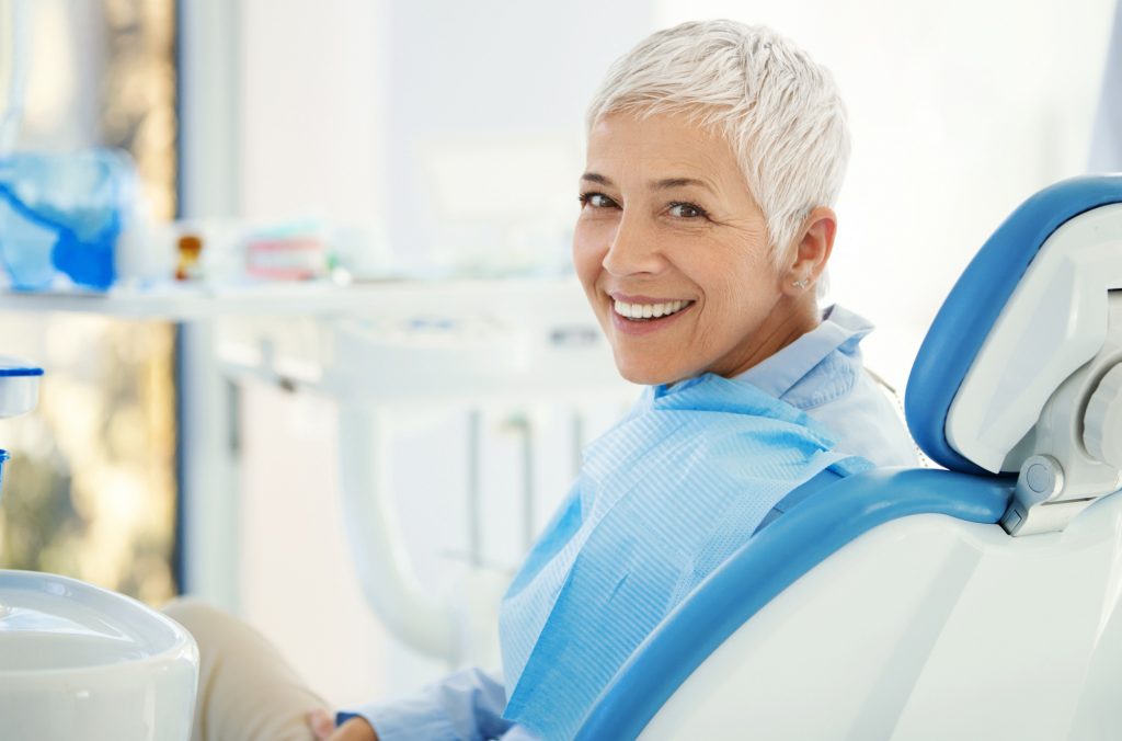 older woman smiling whilst overcoming dental fear in the dentists chair image